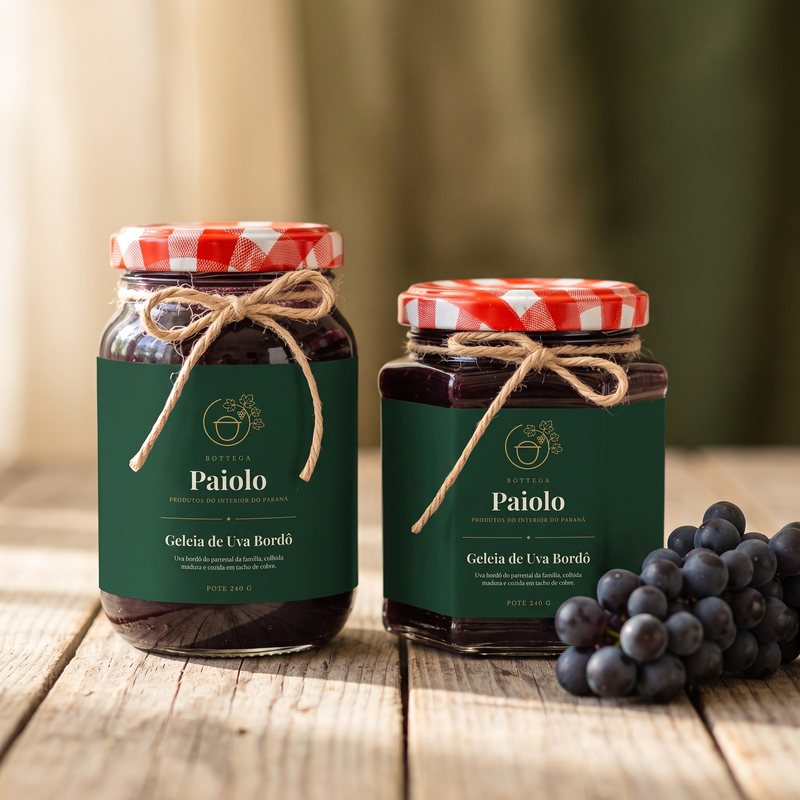 Potes de geleia de uva bordô ao lado de um cacho de uvas